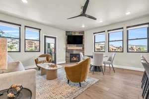 Living room featuring light hardwood / wood-style flooring, a fireplace, and ceiling fan