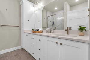 Bathroom featuring dual vanity and wood-type flooring