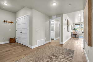 Corridor with light hardwood / wood-style flooring