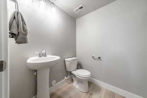 Bathroom featuring sink, a textured ceiling, toilet, and hardwood / wood-style floors