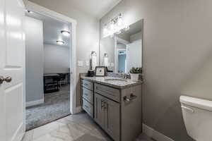 Bathroom featuring vanity, tile patterned flooring, and toilet