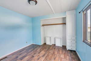 Unfurnished bedroom with a closet and hardwood / wood-style flooring