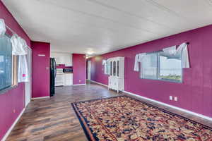 Unfurnished living room with dark wood-type flooring