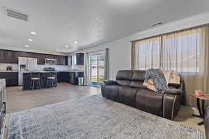 Living room with sink, a textured ceiling, and light hardwood / wood-style floors