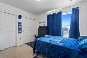 Carpeted bedroom featuring a textured ceiling and a closet