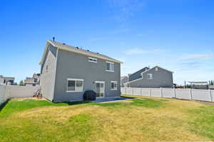 Back of property featuring a lawn and a patio area