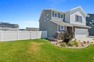 View of side of home with a garage and a lawn