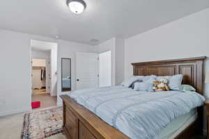 Master Bedroom with a closet, a spacious closet, a textured ceiling, and light colored carpet