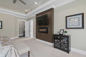 Living room featuring crown molding, light colored carpet, a raised ceiling, and ceiling fan