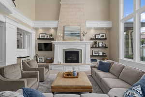 Living room with a high ceiling and a fireplace