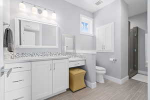 3/4 Bathroom featuring vanity, toilet, a shower with door, and tile patterned flooring