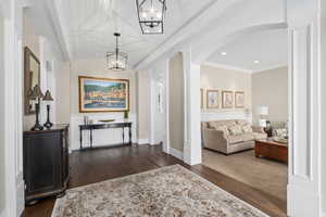 Interior space featuring barrel ceiling, dark hardwood / wood-style flooring, a notable chandelier, and ornamental molding