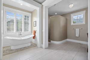 Master Bathroom with a bathing tub and tile patterned floors  Walk in shower