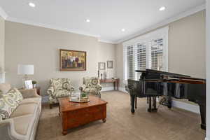 Carpeted living room featuring crown molding