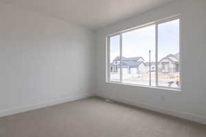 Carpeted empty room featuring a healthy amount of sunlight