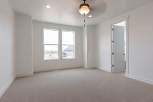 Empty room featuring light carpet and ceiling fan