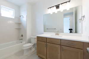 Full bathroom featuring bathing tub / shower combination, vanity, tile patterned flooring, and toilet