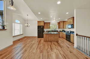 Dining area under chandelier and at bar at the back of the large kitchen island. Recently refinished hardwood floors.