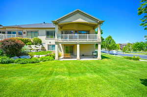 Back of Twin home featuring a balcony, a patio area, and a lawn