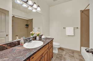 Full bathroom with shower / bathtub combination, vanity, tile patterned flooring, and toilet