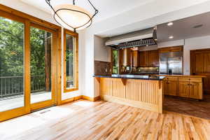 Kitchen with light tile patterned flooring, built in fridge, backsplash, and a wealth of natural light