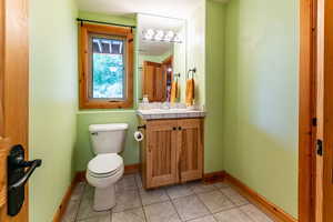 3/4 Bathroom with vanity, tile patterned flooring, and toilet