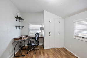 Office area featuring wood-type flooring and vaulted ceiling