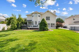 Rear view of house featuring a yard