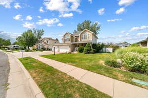 View of front facade featuring a garage and a front lawn