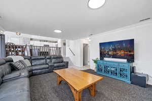 Living room with ornamental molding and carpet