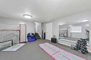 Exercise area featuring carpet floors and a textured ceiling