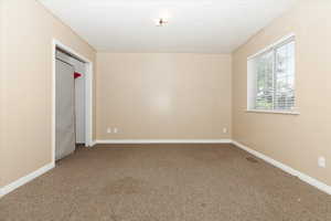 Unfurnished bedroom featuring carpet flooring and a closet