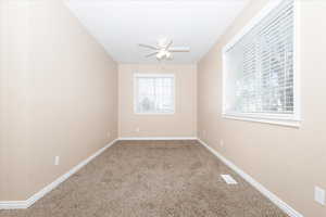 Carpeted empty room with ceiling fan