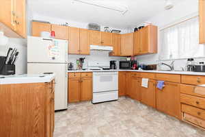 Kitchen with white appliances and light tile patterned floors