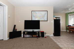 Living room featuring light tile patterned flooring and ceiling fan