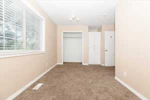 Unfurnished bedroom with light carpet