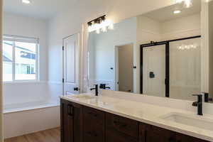 Bathroom with vanity, separate shower and tub, and wood-type flooring