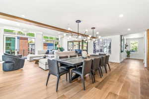 Dining room with light hardwood / wood-style flooring, a notable chandelier, and a wealth of natural light