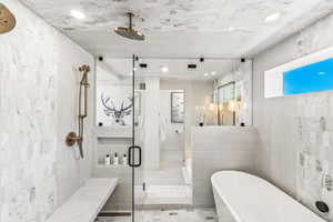 Bathroom featuring plus walk in shower, tile patterned floors, and tile walls