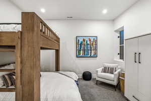 Carpeted bedroom featuring a closet