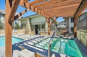 View of pool featuring a pergola, a patio, and a hot tub