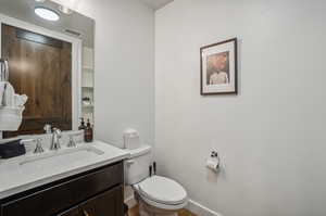 Bathroom featuring vanity, toilet, and hardwood / wood-style flooring