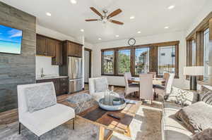 Living room with sink, ceiling fan, and wood-type flooring