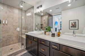 Bathroom with dual vanity and a shower with door