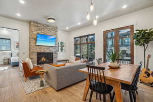 Dining space with a fireplace and light hardwood / wood-style floors