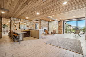 Unfurnished living room featuring a fireplace, beamed ceiling, wood ceiling, and light tile patterned floors