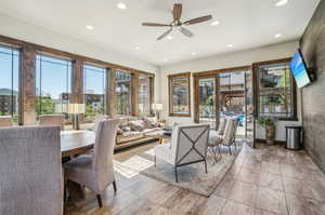 Living room with ceiling fan, a healthy amount of sunlight, and light tile patterned floors