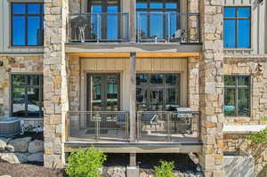 Entrance to property with a balcony, french doors, and cooling unit