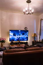 Carpeted living room with an inviting chandelier