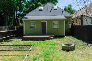 Rear view of house with a yard, central AC, a deck, and a fire pit